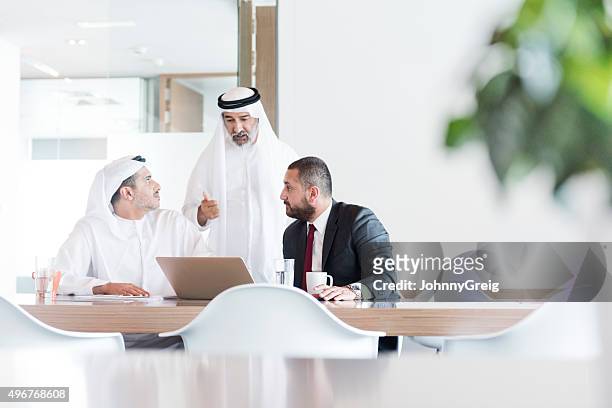 tres hombres de negocios árabe en reunión de negocios en la oficina moderna - gulf countries fotografías e imágenes de stock