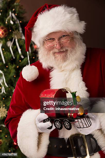 real santa claus holding toy train - st nicholas stock pictures, royalty-free photos & images