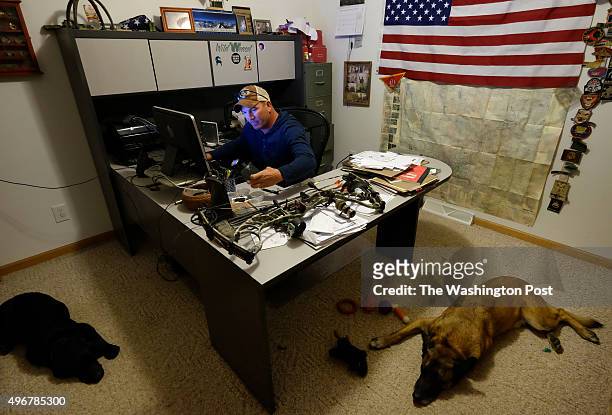 Sergeant 1st Class Matthew Bessler works in his home office with the company of his dogs Ziva and Mike 5 "Michael", right, at his home in Powell, WY...