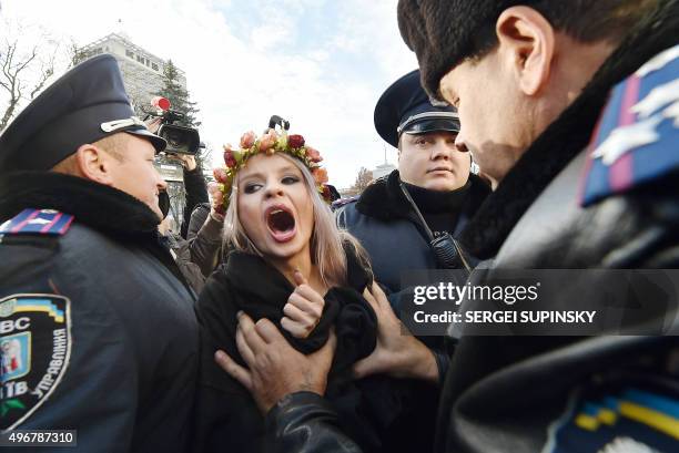 Ukrainian police detain an activist of the feminist movement Femen as she shouts slogans during a demonstration calling for gay rights outside the...