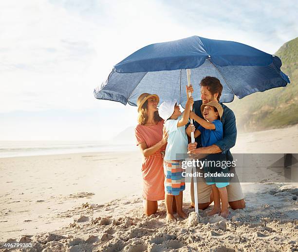 setting up the shade - beach umbrella stock pictures, royalty-free photos & images