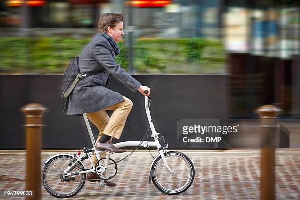 mittleren alter geschäftsmann zum büro mit dem fahrrad - klapprad business stock-fotos und bilder