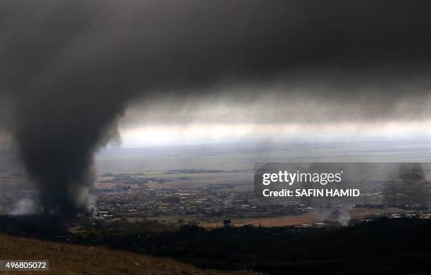 Heavy smoke covers the northern Iraqi town of Sinjar during an operation by Iraqi Kurdish forces backed by US-led strikes on November 12 to retake...