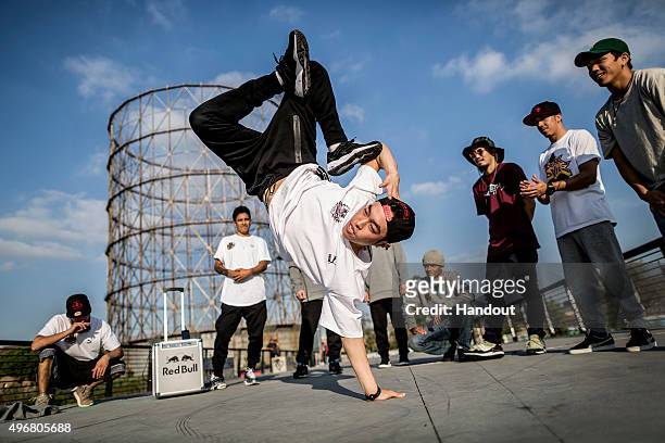 In this handout image provided by Red Bull, Jong Ho "Leon" Kim of Korea performs as the other B-Boys watch on during a video production prior to this...