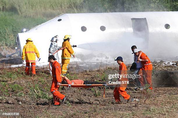 Rescue personnel extinguish a mock aircraft wreckage while other personnel evacuate a person on a stretcher during the Crash-Rescue Exercise at the...