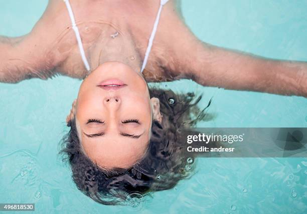 frau entspannen am swimmingpool - schönheit frau wasser gesicht stock-fotos und bilder