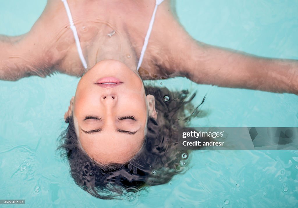 Woman relaxing in the swimming pool