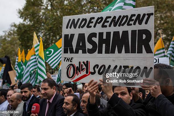 Protestors chant and wave the flag of Azad Jammu and Kashmir, a self-governing administrative division of Pakistan, during a protest on Whitehall...