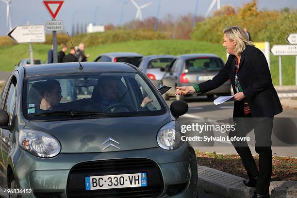 French Far-Right National Front President Marine Le Pen distributes campaign leaflets at the main entrance of french car maker Renault factory on...