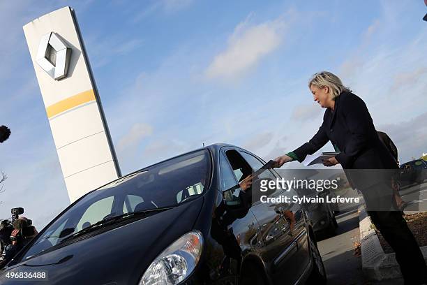 French Far-Right National Front President Marine Le Pen distributes campaign leaflets at the main entrance of french car maker Renault factory on...