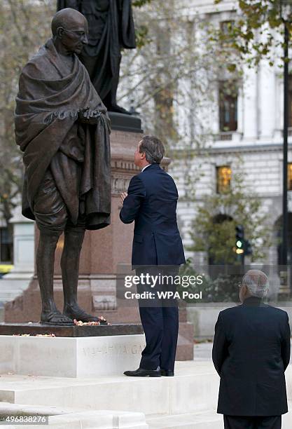 British Prime Minister David Cameron and India's Prime Minister Narendra Modi pay homage to the statue of Mahatma Ghandi in Parliament Square during...