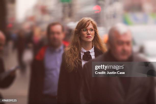 business woman walking in a crowded street - pedestrians stock-fotos und bilder