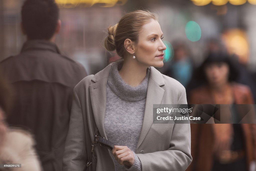 Classy woman starring away on a crowded street