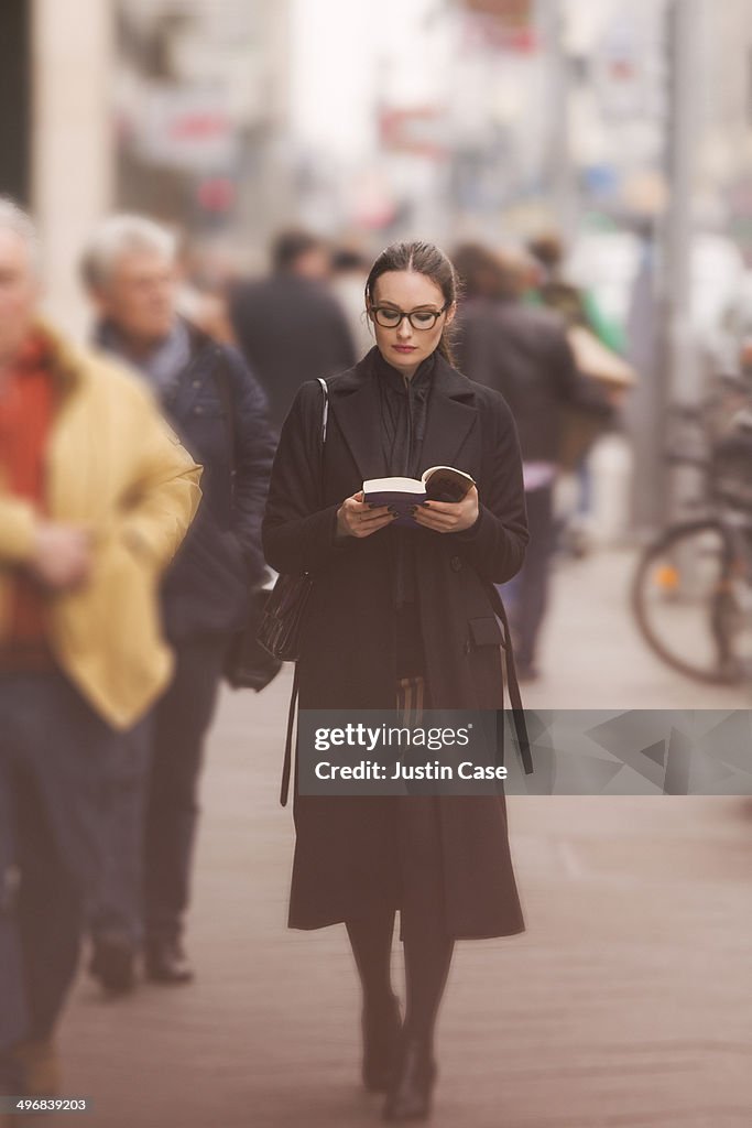 Classy woman walking and reading in the street