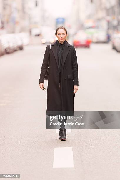 classy business woman standing on a city road - coat stock-fotos und bilder