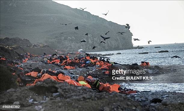 Picture taken on November 12, 2015 shows life vests left by migrants and refugees after arriving on the shores of the Greek island of Lesbos after...