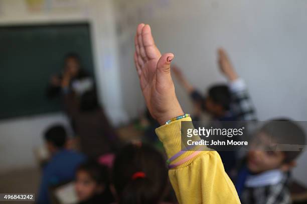Girls raises her hand during class on November 12, 2015 in Qamishli, Rojava, Syria. With the fall of the Syrian regime and successes against ISIS in...