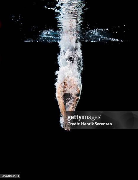 young swimmer breaking the surface - in het water duiken stockfoto's en -beelden