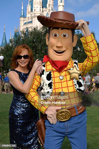 In this handout provided by Disney Parks, Reba McEntire poses with Woody from Disney-Pixar "Toy Story" during a break from taping the 'Disney Parks...