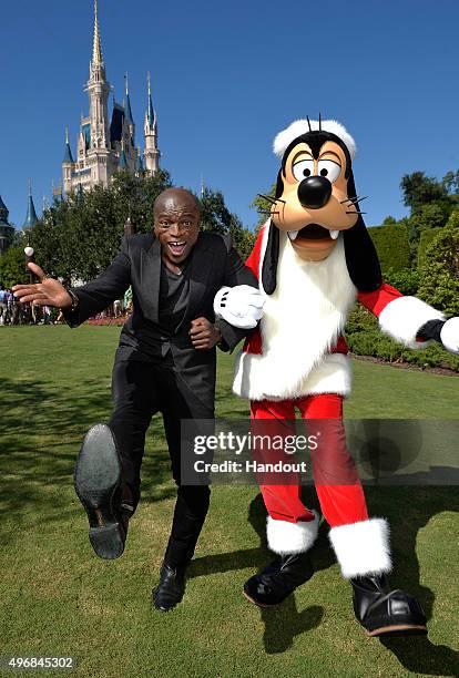 In this handout provided by Disney Parks, Seal poses with Santa Goofy during a break from taping the 'Disney Parks Unforgettable Christmas...