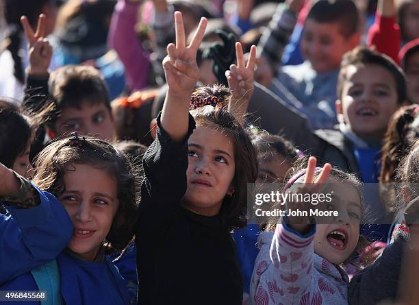 Children flash the victory sign after singing the Rojava anthem at a public elementary school on November 12, 2015 in Qamishli, Rojava, Syria....