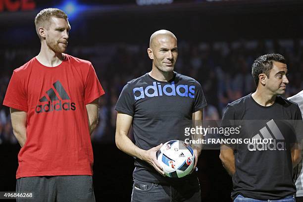 Former French soccer player Zinedine Zidane , holding the official football of the upcoming Euro 2016 football championships, poses with Arsenal's...