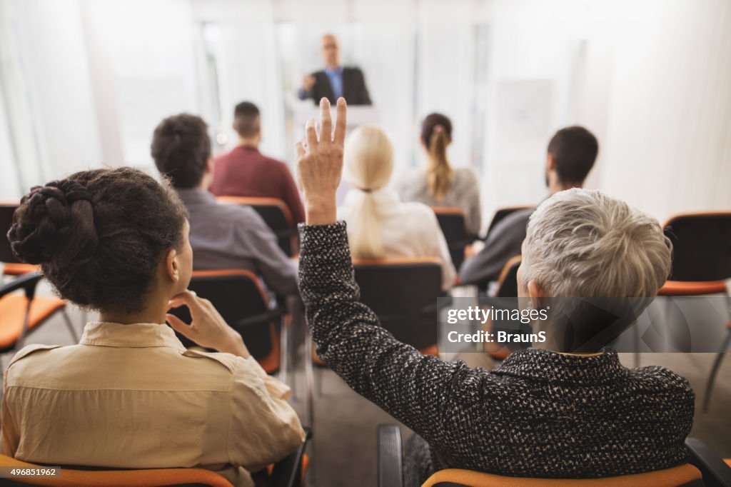 Back view of a businesswoman asking a question on seminar.