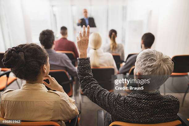 back view of a businesswoman asking a question on seminar. - attending course stock pictures, royalty-free photos & images