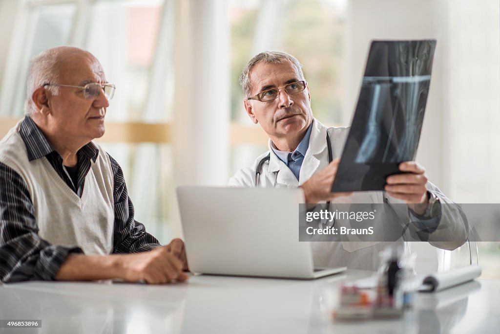 Médico analisar um exame médico com seu paciente idoso.