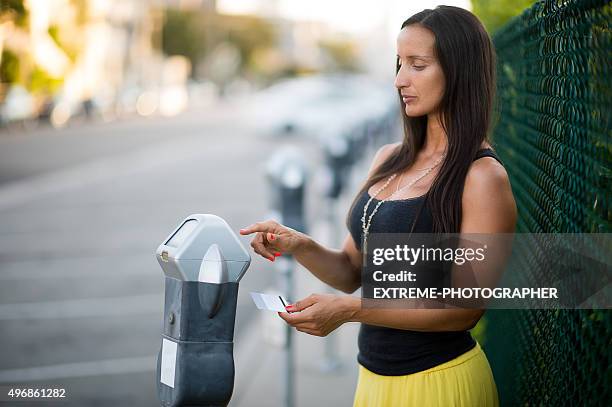 frau mit parkuhr - parking meter stock-fotos und bilder