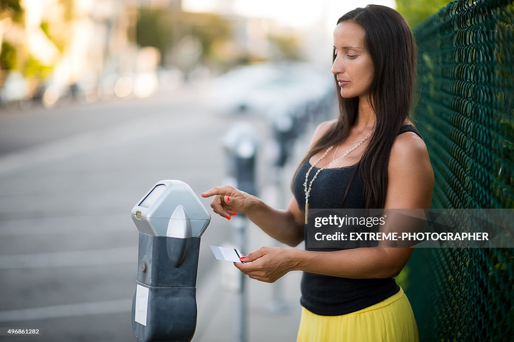 Woman using parking meter