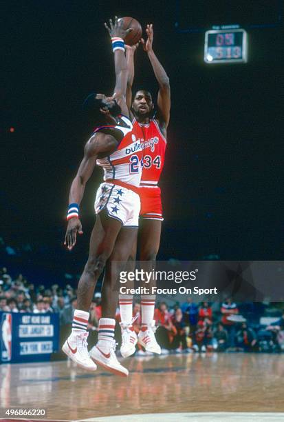 David Greenwood of the Chicago Bulls shoots over Spencer Haywood of the Washington Bullets during an NBA basketball game circa 1981 at the Capital...