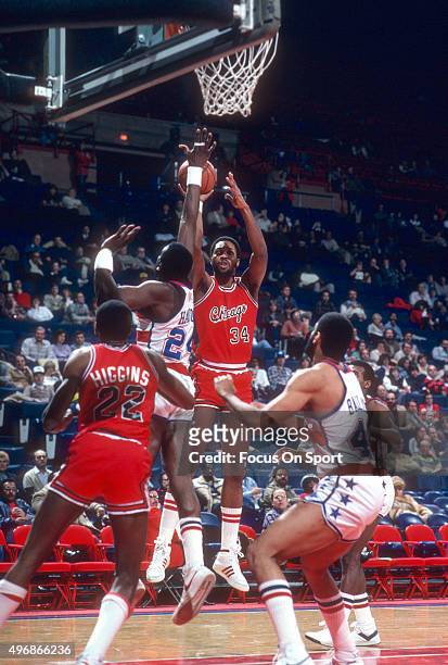 David Greenwood of the Chicago Bulls shoots over Spencer Haywood of the Washington Bullets during an NBA basketball game circa 1982 at the Capital...