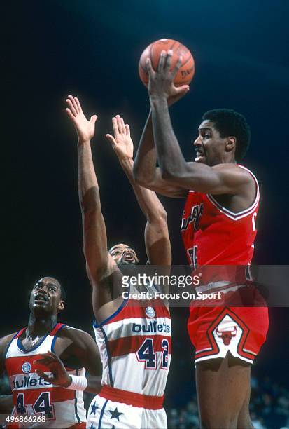David Greenwood of the Chicago Bulls shoots over Greg Ballard of the Washington Bullets during an NBA basketball game circa 1983 at the Capital...