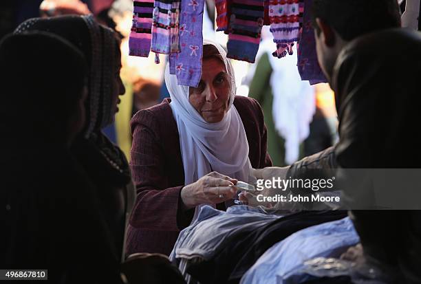 Woman shops for clothing in an outdoor bazaar on November 12, 2015 in Qamishli, Rojava, Syria. The autonomous Rojava government in northern Syria has...