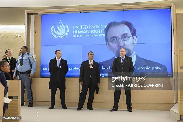 Body guards stand in front of a screen showing United Nations High Commissioner for Human Rights Prince Zeid Ra'ad Zeid Al-Hussein delivering a...