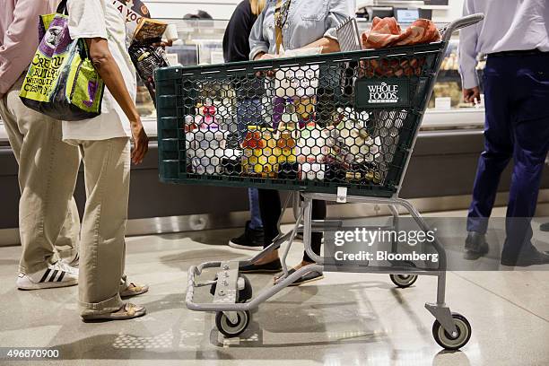 Whole Foods Market Inc. Signage is displayed on a shopping cart as customers browse the prepared foods section of the new store in downtown Los...