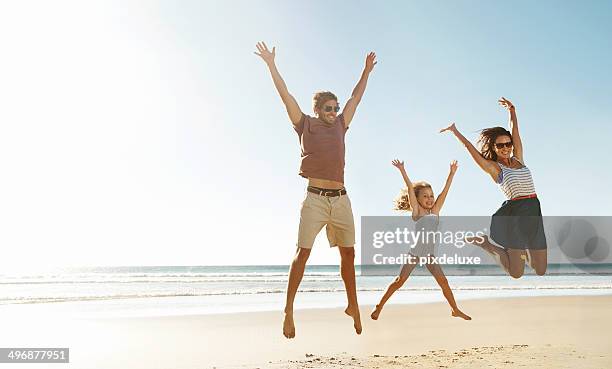 freedom of happiness - beach family jumping stock pictures, royalty-free photos & images