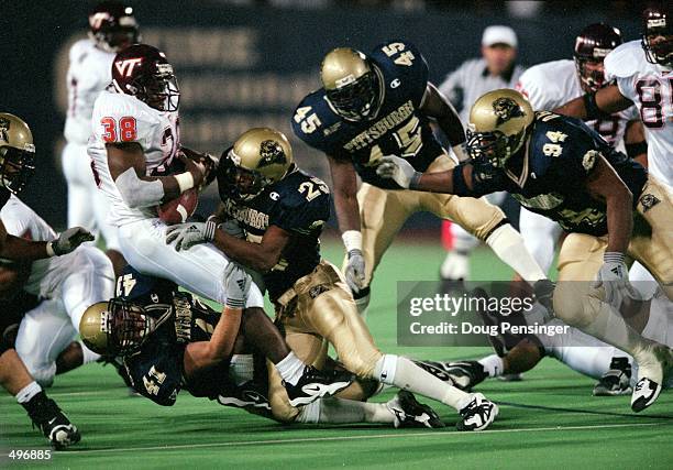 Shyrone Stith of the Virginia Tech Hokies carries the ball as he is tackles by Scott Micurley and Ramon Walker of the Pittsburgh Panthers at the Pitt...