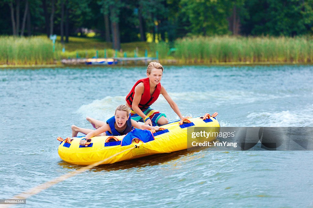 Boy and Girl Children Tubing on Minnesota Lake in Summer