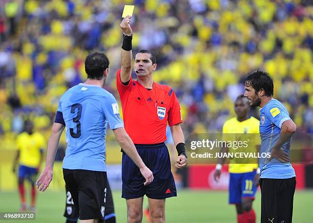 Brazilian referee Ricardo Marques Ribeiro shows a yellow card to Uruguay's Diego Godin during their Russia 2018 FIFA World Cup South American...