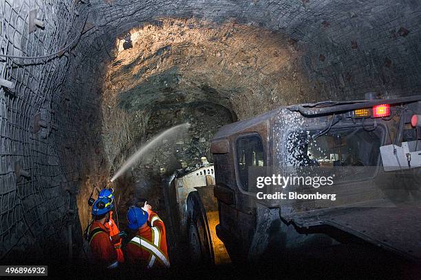 Contractors stand next to a machine while working at the underground Glencore Plc Bracemac-McLeod zinc mine in Malartic, Quebec, Canada, on Friday,...