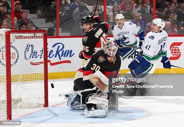 Sven Baertschi of the Vancouver Canucks scores a first period goal against Andrew Hammond of the Ottawa Senators as Chris Wideman of the Ottawa...