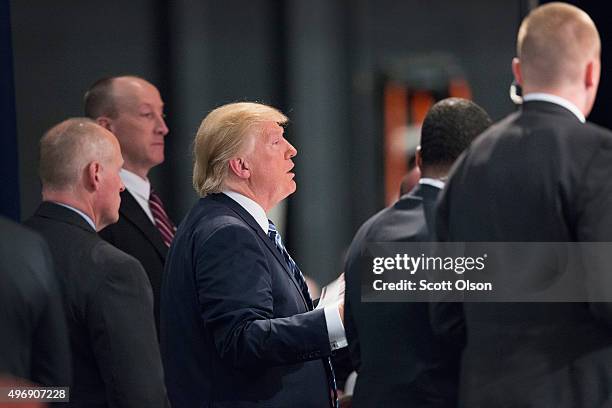 Flanked by a members of his Secret Service detail Republican presidential candidate Donald Trump greets guests during a campaign stop at Iowa Central...