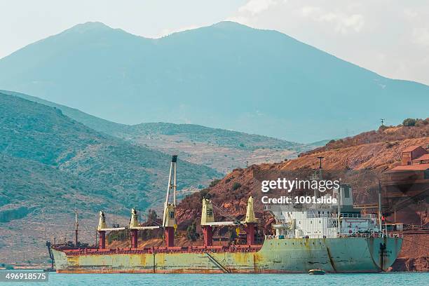 bulk carrier ship is loading bauxite ore itea port town - itea greece stock pictures, royalty-free photos & images