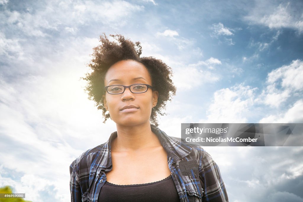 Confident street smart young black female with dramatic sky