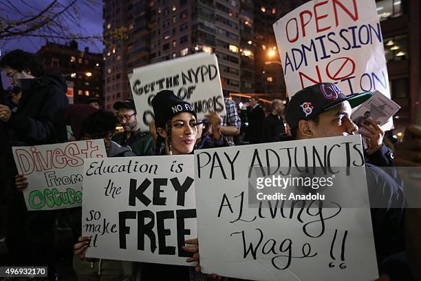 Students hold placards as they stage a demonstration at the Hunter College, which is a part of New York City University, to protest ballooning...