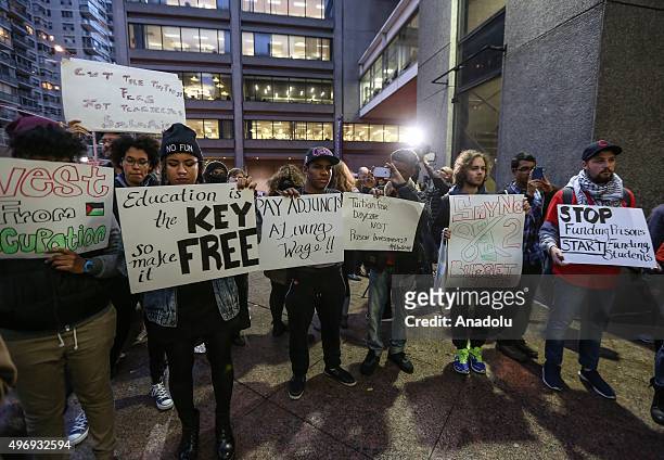 Students hold placards as they stage a demonstration at the Hunter College, which is a part of New York City University, to protest ballooning...