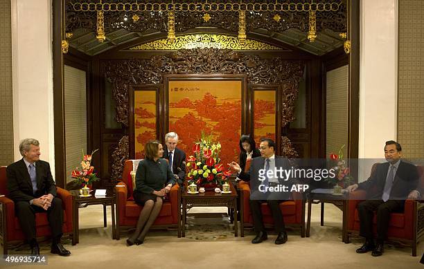 Ambassador to China Max Baucus , US House Minority Leader Nancy Pelosi of California , and Chinese Foreign Minister Wang Yi listen as Chinese Premier...