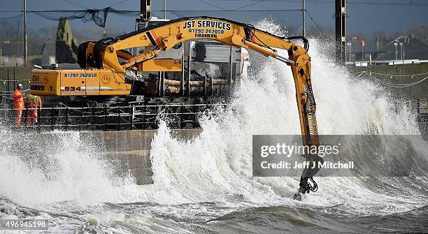 Workmen place large rocks in the sea to bolster flood defences along the sea wall on November 13, 2015 in Saltcoats, Scotland. Storm Abigail has...